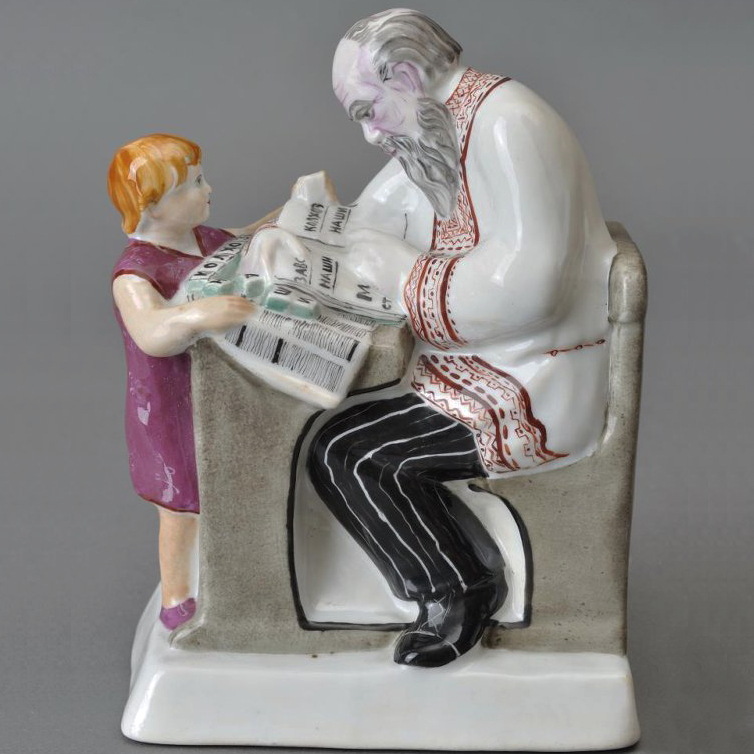 Soviet propaganda porcelain figural group "Likbez" modeled by Kazimir Rizhov. A girl teaching an old man how to read. Lomonosov State Porcelain Factory, St Petersburg, USSR.