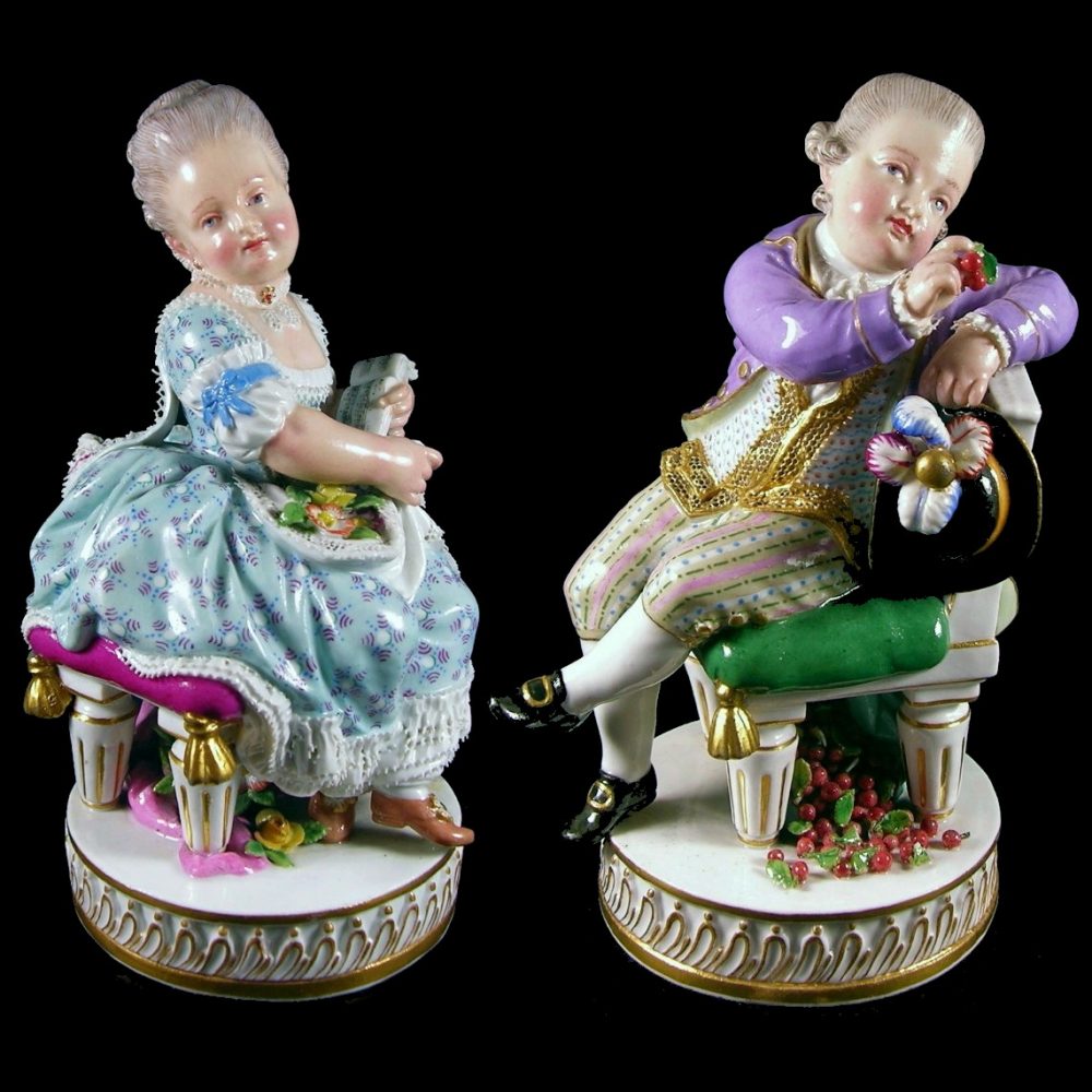 Meissen figurines of a boy with cherry & girl with music script. Model number F51